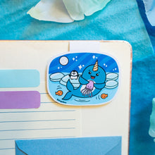 Load image into Gallery viewer, A joyful magnetic bookmark featuring a cute narwhal with a big smile, swimming through the ocean. This eco-friendly bookmark has a playful, hand-drawn style, perfect for adding a touch of whimsical charm to your reading! 🦄🌊📖✨