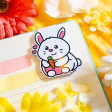 Load image into Gallery viewer, An adorable magnetic bookmark featuring a happy bunny hugging a bright orange carrot. This eco-friendly bookmark has a cute, hand-drawn style, perfect for adding a touch of sweetness to your reading! 🐰🥕📖✨