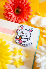 Load image into Gallery viewer, An adorable magnetic bookmark featuring a happy bunny hugging a bright orange carrot. This eco-friendly bookmark has a cute, hand-drawn style, perfect for adding a touch of sweetness to your reading! 🐰🥕📖✨