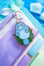 Load image into Gallery viewer, A charming wooden keychain featuring a cute manatee floating serenely in the water. This eco-friendly keychain has a natural, hand-carved design, perfect for adding a touch of ocean love to your keys or bag! 🌊🐘✨