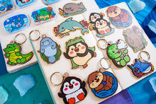 Load image into Gallery viewer, A charming wooden keychain featuring a cute manatee floating serenely in the water. This eco-friendly keychain has a natural, hand-carved design, perfect for adding a touch of ocean love to your keys or bag! 🌊🐘✨