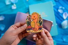 Load image into Gallery viewer,  A charming bamboo sticker featuring a regal seahorse adorned with a tiny crown, floating gracefully in the ocean. This eco-friendly sticker has a whimsical, hand-drawn style, perfect for decorating laptops, water bottles, and journals! 👑🐉✨