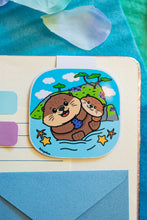 Load image into Gallery viewer, A delightful magnetic bookmark featuring a playful Monterey otter floating on its back, holding a seashell. This eco-friendly bookmark has a cute, hand-drawn style, perfect for adding a touch of ocean charm to your reading! 🦦🌊📖✨