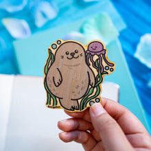 Load image into Gallery viewer, : An adorable bamboo sticker featuring a playful seal and a friendly jellyfish floating together in the ocean. This eco-friendly sticker has a cute, hand-drawn style, perfect for decorating laptops, water bottles, and journals! 🦭💙✨