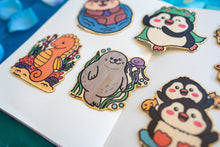 Load image into Gallery viewer, : An adorable bamboo sticker featuring a playful seal and a friendly jellyfish floating together in the ocean. This eco-friendly sticker has a cute, hand-drawn style, perfect for decorating laptops, water bottles, and journals! 🦭💙✨