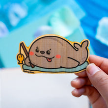 Load image into Gallery viewer, A cute bamboo sticker featuring a cheerful seal holding a tiny fishing rod, patiently waiting for a catch. This eco-friendly sticker has a charming, hand-drawn style, perfect for decorating laptops, water bottles, and journals! 🦭🎣✨