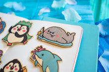 Load image into Gallery viewer, A cute bamboo sticker featuring a cheerful seal holding a tiny fishing rod, patiently waiting for a catch. This eco-friendly sticker has a charming, hand-drawn style, perfect for decorating laptops, water bottles, and journals! 🦭🎣✨