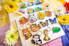 Load image into Gallery viewer, A delightful wooden keychain featuring a cute giraffe with a long neck and a friendly smile. This eco-friendly keychain has a charming, hand-carved design, perfect for adding a touch of jungle-inspired fun to your keys or bag! 🦒🌿✨