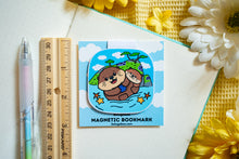 Load image into Gallery viewer, A glossy sticker featuring a cute otter with a playful expression. The otter is either floating on its back or holding a small object, giving off an adorable and cheerful vibe.
Let me know if you’d like any edits! 😊🦦✨