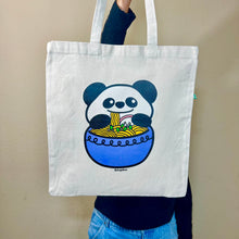 Load image into Gallery viewer, A playful tote bag featuring a cute panda happily enjoying a bowl of ramen with chopsticks. This eco-friendly bag has an adorable hand-drawn design, perfect for ramen lovers and panda fans alike! 🐼🍜✨