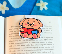 Load image into Gallery viewer, A cute magnetic bookmark featuring a playful puppy eagerly reading a book with a focused expression. This eco-friendly bookmark has a charming, hand-drawn style, perfect for adding a touch of puppy love to your reading! 🐶📖✨