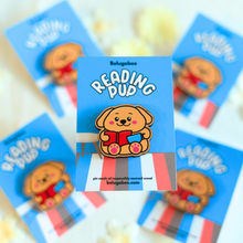 Load image into Gallery viewer, A charming wooden pin featuring a cute puppy with glasses, deeply focused on reading a book. This eco-friendly pin has a delightful, hand-carved design, perfect for adding a touch of puppy love to your accessories! 🐶📖✨