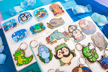 Load image into Gallery viewer, A cute sea otter floating happily on its back, holding a seashell with a cheerful expression. This eco-friendly bamboo sticker features a charming, hand-drawn style, perfect for decorating laptops, water bottles, and journals! 🦦💙✨