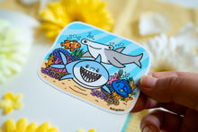 Load image into Gallery viewer, A bold glossy sticker featuring a sleek shark swimming through the ocean with a fierce yet playful expression. This eco-friendly sticker has a dynamic, hand-drawn style, perfect for adding an adventurous touch to your laptop, water bottle, or notebook! 🦈🌊✨