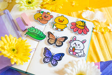 Load image into Gallery viewer, The Special Spring Magnetic Bookmark Set is a collection of five charming bookmarks, each featuring unique spring-themed designs. These bookmarks are double-sided, with a protective laminate on the front that provides a glossy finish. Each bookmark measures approximately 2.4 inches on its longest side and contains a strong rectangular magnet inside to securely hold your page without causing damage. Please note that colors may vary slightly from the pictures due to lighting and other factors. This set includ