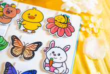 Load image into Gallery viewer, The Special Spring Magnetic Bookmark Set is a collection of five charming bookmarks, each featuring unique spring-themed designs. These bookmarks are double-sided, with a protective laminate on the front that provides a glossy finish. Each bookmark measures approximately 2.4 inches on its longest side and contains a strong rectangular magnet inside to securely hold your page without causing damage. Please note that colors may vary slightly from the pictures due to lighting and other factors. This set includ