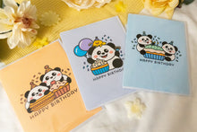 Load image into Gallery viewer, A charming birthday card featuring adorable pandas, each with a joyful expression, surrounding a delicious-looking cupcake topped with colorful frosting and a candle. The card includes the message "Happy Birthday" in playful, vibrant lettering, adding a festive touch to the celebration