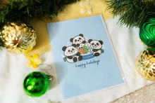 Load image into Gallery viewer, A delightful set of holiday greeting cards featuring whimsical, festive designs. Each card showcases unique artwork, including a cheerful snowman with a cozy scarf, a Christmas tree adorned with colorful ornaments, a playful reindeer with twinkling lights tangled in its antlers, and a warm fireplace scene with stockings hung with care. The cards are accented with gold foil details, vibrant colors, and charming holiday-themed illustrations, perfect for spreading joy and festive cheer to family and friends.