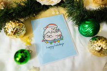 Load image into Gallery viewer, A delightful set of holiday greeting cards featuring whimsical, festive designs. Each card showcases unique artwork, including a cheerful snowman with a cozy scarf, a Christmas tree adorned with colorful ornaments, a playful reindeer with twinkling lights tangled in its antlers, and a warm fireplace scene with stockings hung with care. The cards are accented with gold foil details, vibrant colors, and charming holiday-themed illustrations, perfect for spreading joy and festive cheer to family and friends.