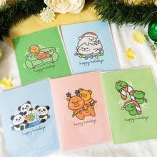 Load image into Gallery viewer, A delightful set of holiday greeting cards featuring whimsical, festive designs. Each card showcases unique artwork, including a cheerful snowman with a cozy scarf, a Christmas tree adorned with colorful ornaments, a playful reindeer with twinkling lights tangled in its antlers, and a warm fireplace scene with stockings hung with care. The cards are accented with gold foil details, vibrant colors, and charming holiday-themed illustrations, perfect for spreading joy and festive cheer to family and friends.