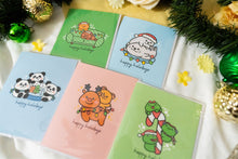 Load image into Gallery viewer, A delightful set of holiday greeting cards featuring whimsical, festive designs. Each card showcases unique artwork, including a cheerful snowman with a cozy scarf, a Christmas tree adorned with colorful ornaments, a playful reindeer with twinkling lights tangled in its antlers, and a warm fireplace scene with stockings hung with care. The cards are accented with gold foil details, vibrant colors, and charming holiday-themed illustrations, perfect for spreading joy and festive cheer to family and friends.