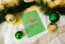 Load image into Gallery viewer, A delightful set of holiday greeting cards featuring whimsical, festive designs. Each card showcases unique artwork, including a cheerful snowman with a cozy scarf, a Christmas tree adorned with colorful ornaments, a playful reindeer with twinkling lights tangled in its antlers, and a warm fireplace scene with stockings hung with care. The cards are accented with gold foil details, vibrant colors, and charming holiday-themed illustrations, perfect for spreading joy and festive cheer to family and friends.