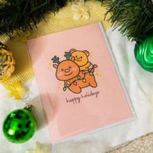 Load image into Gallery viewer, A cheerful holiday card featuring reindeers with bright red noses, wearing festive scarves, and surrounded by snowflakes, creating a joyful and festive atmosphere. The card reads "Happy Holidays" in elegant script, adding to the warmth of the season
