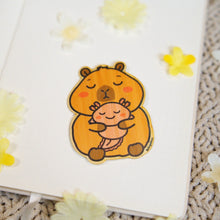Load image into Gallery viewer, bamboo sticker of a capybara holding an axolotl