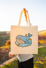 Load image into Gallery viewer, A collection of tote bags featuring playful whale-themed designs. Each bag showcases a unique illustration, such as a whale swimming in a vibrant ocean, a minimalist whale outline, or a whale spouting water. The tote bags are made of sturdy canvas material with neutral-colored backgrounds that make the colorful whale designs pop. Perfect for carrying groceries, books, or everyday essentials.