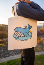 Load image into Gallery viewer, A collection of tote bags featuring playful whale-themed designs. Each bag showcases a unique illustration, such as a whale swimming in a vibrant ocean, a minimalist whale outline, or a whale spouting water. The tote bags are made of sturdy canvas material with neutral-colored backgrounds that make the colorful whale designs pop. Perfect for carrying groceries, books, or everyday essentials.