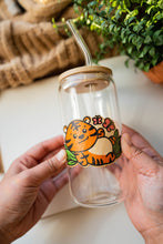 Load image into Gallery viewer, A glass cup with a bamboo sticker featuring a cute baby tiger resting on it, surrounded by colorful butterflies fluttering around