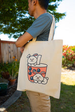 Load image into Gallery viewer, Belugabee Bamboo Sticker: Adorable bunnies enjoying boba on a tote bag hanging on a shoulder. Elevate your style with this eco-friendly 3x3-inch sticker. 🐇🍵 #BambooSticker #BunniesAndBoba #ToteBagDecor