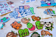 Load image into Gallery viewer, Unboxing a Belugabee Grade A Mystery Bag: Excitement as hands unwrap cute surprises, including tote bags, pencil pouches, memo pads, bamboo stickers, sticker sheets, die-cut stickers, and pins. A joyous discovery awaits! 🎁🛍️ #MysteryBagUnboxing #SurpriseGifts #CuteSurprises