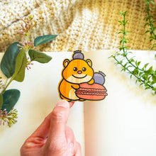 Load image into Gallery viewer, Belugabee Hamster Macaron Bamboo Sticker Alt Text: Cute hamster holding a macaroon with a playful blueberry perched on its head, intricately designed on eco-friendly bamboo. 🐹🍬 #BambooSticker #HamsterMacaronDesign #AdorableDecor