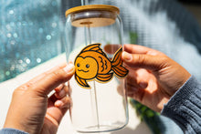 Load image into Gallery viewer, Belugabee Bamboo Sticker: Whimsical goldfish design, enhancing the charm of your glass cup. Elevate your style with this eco-friendly and delightful 3x3-inch bamboo sticker. 🐠🌿 #BambooSticker #GoldfishDesign #GlassCupDecor