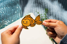 Load image into Gallery viewer, Belugabee Bamboo Sticker: Whimsical goldfish design, crafted on eco-friendly bamboo. Elevate your style with this charming 3x3-inch sticker. 🐠🌿 #BambooSticker #GoldfishDesign #NatureInspiredArt
