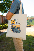 Load image into Gallery viewer, Kittens Boba Tote Bag being carried by a stylish individual, showcasing the cute feline design and adding a touch of whimsy to your daily outings. 🐱👜 #KittensBoba #ToteBagStyle #BambooArtistry
