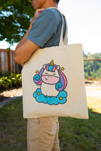 Load image into Gallery viewer, A dreamy tote bag featuring a majestic unicorn surrounded by sparkling stars and a soft, magical aura. This eco-friendly bag has a whimsical, hand-drawn design, perfect for unicorn lovers and everyday adventures! 🦄✨💖