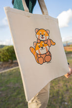Load image into Gallery viewer, A heartwarming design featuring a loving red panda mom cuddling her adorable baby, surrounded by soft nature-inspired details. Printed on a sturdy, eco-friendly tote bag, perfect for carrying books, groceries, and everyday essentials. A must-have for red panda lovers!