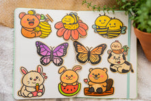 Load image into Gallery viewer, A cozy, sleepy bee curled up with tiny "Zzz" floating above, resting on a fluffy flower. This eco-friendly bamboo sticker has a soft, hand-drawn style, perfect for adding a touch of charm to laptops, water bottles, and journals