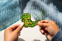 Load image into Gallery viewer, Infuse a hint of wild charm with our Crocodile Bamboo Sticker. This eco-friendly 3x3-inch sticker showcases a captivating crocodile design, meticulously crafted on sustainable bamboo. Add a touch of nature-inspired flair to any surface and express your unique style. Elevate your accessories with the distinctive and eco-conscious Crocodile Bamboo Sticker. 🐊🌿 #BambooSticker #CrocodileDesign #EcoFriendlyDecor