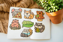 Load image into Gallery viewer, Belugabee Bamboo Sticker Collection: A delightful arrangement of seven unique designs, including Fairy Bear, Duckies, Elephant Family, and more, showcased on a notebook. Elevate your style with these charming and eco-friendly 3x3-inch bamboo stickers. 🌈🐻🦆🐘 #BambooStickers #UniqueDesigns #EcoFriendlyDeco