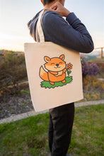 Load image into Gallery viewer, A Fox and Flower Tote Bag is a charming accessory that combines the playful imagery of a fox with the natural beauty of flowers. These tote bags often feature illustrations or designs depicting foxes amidst floral patterns, creating a whimsical and nature-inspired aesthetic. Crafted from durable materials like canvas or linen, they are both functional and stylish, suitable for carrying everyday essentials or serving as a unique gift for nature and animal lovers.