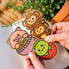 Load image into Gallery viewer, A surprise collection of eco-friendly bamboo stickers featuring adorable animals, whimsical creatures, and delightful designs! Each pack contains a unique mix, making it a fun mystery to unwrap. Perfect for decorating water bottles, laptops, journals, and more!"