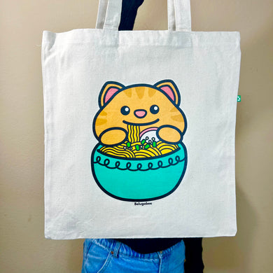 Belugabee Eco-Friendly Tote Bag: Front side featuring a yellow cat enjoying ramen from a blue bowl on a brown tote. Elevate your style with this delightful and sustainable accessory. 🐱🍜 #EcoFriendlyTote #YellowCat #RamenLover