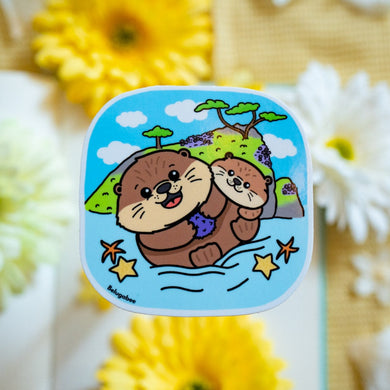 A glossy sticker featuring a cute otter with a playful expression. The otter is either floating on its back or holding a small object, giving off an adorable and cheerful vibe.

Let me know if you’d like any edits! 😊🦦✨