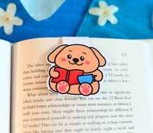 Load image into Gallery viewer, A cute magnetic bookmark featuring a playful puppy eagerly reading a book with a focused expression. This eco-friendly bookmark has a charming, hand-drawn style, perfect for adding a touch of puppy love to your reading! 🐶📖✨
