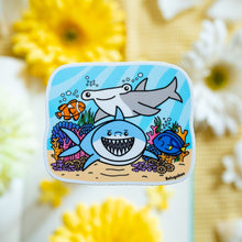 Load image into Gallery viewer, A bold glossy sticker featuring a sleek shark swimming through the ocean with a fierce yet playful expression. This eco-friendly sticker has a dynamic, hand-drawn style, perfect for adding an adventurous touch to your laptop, water bottle, or notebook! 🦈🌊✨
