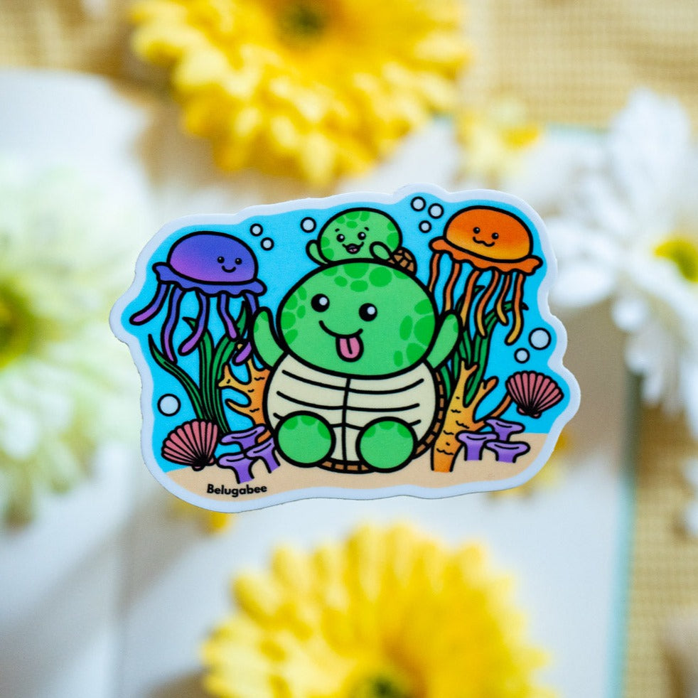 A glossy sticker depicting a mother and baby turtle swimming among jellyfish and coral reefs. Available at Modern Mous