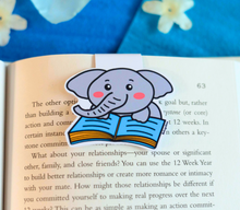 Load image into Gallery viewer, An elephant magnetic bookmark is a functional and charming accessory designed to help readers keep their place in a book. Typically featuring an illustration of an elephant, these bookmarks are made from durable materials like laminated cardstock or vinyl, with strong magnets on each side to securely hold the bookmark in place.

